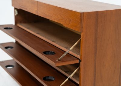 Teak shoe cabinet (Germany, 1960s). The cabinet features two small drawers and three shelves for shoe storage. It is made of teak and has a black lacquered frame with black inset handles that allow for proper ventilation. The cabinet is in good condition, with some visible signs of use.