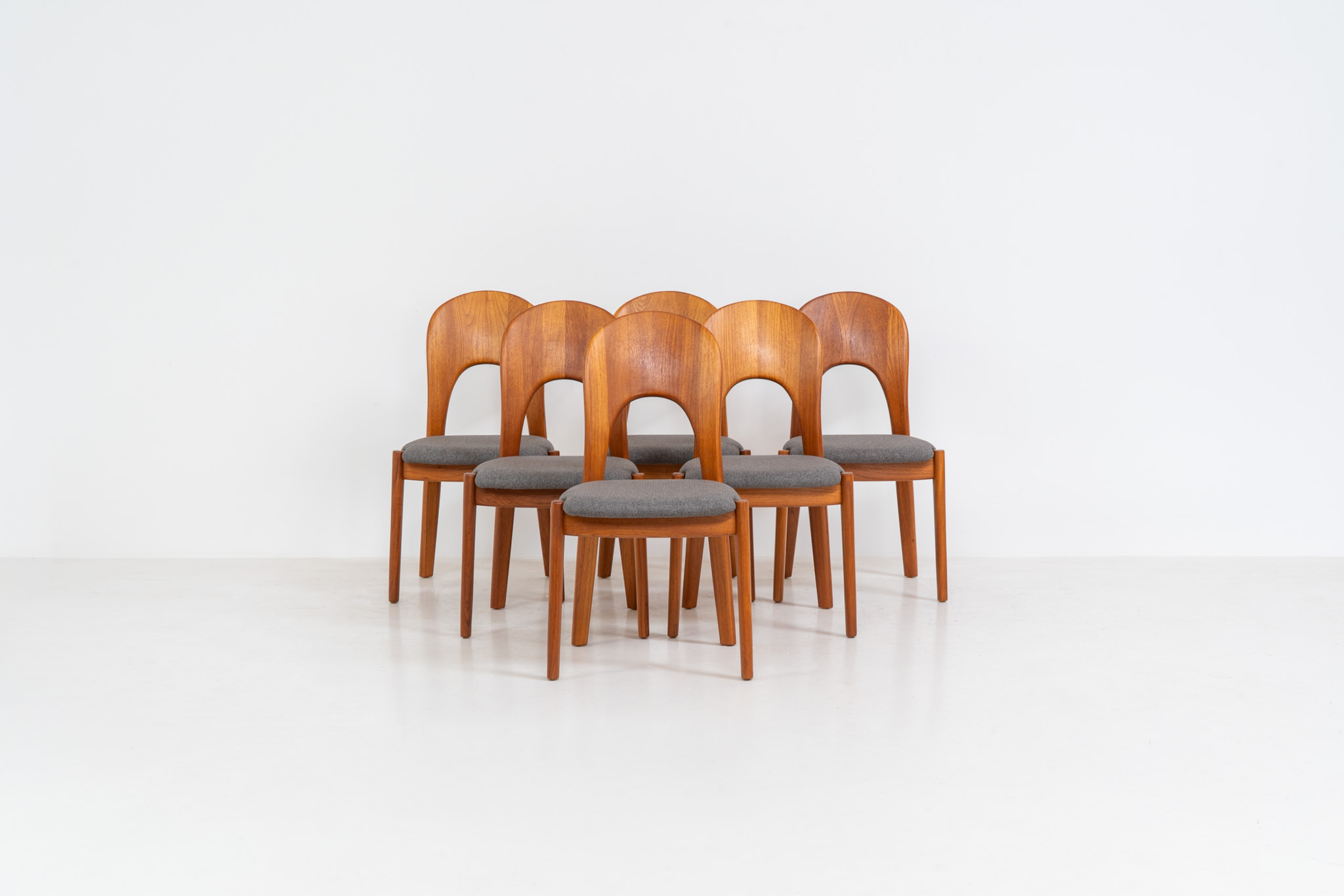 Set of 6 “Morten” dining chairs by Niels Koefoed (Denmark, 1960s). An elegant and sculptural design defined by its organic lines, crafted in solid teak with a rich, warm grain. The chairs have been professionally reupholstered in a refined grey fabric, offering a clean, contemporary contrast to the timeless wooden frame. Presented in excellent condition and ready for another lifetime.