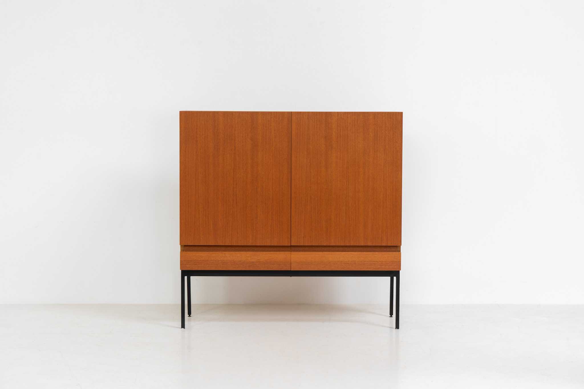 Rare S21 highboard in teak by Dieter Waeckerlin for Behr (Germany, 1950s). Belonging to the same series as the iconic B60, this very hard to find S21 mid sized highboard in teak is a masterful blend of minimalistic design and functional elegance. It’s unbelievable this piece was made in the 50’s and is yet so timeless. It contains two drawers and two doors with a minimal gap between them. The inside offers lots of storage space with adjustable shelves. It is in amazing condition with minimal sings of use and age.