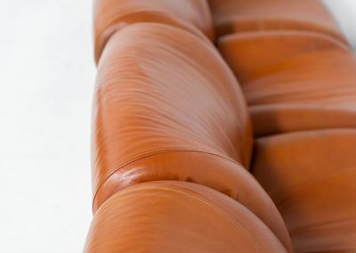 Modular sofa by Doimo Salotti (Italy, 1970s). Striking and bold modular seating system consisting of five identical elements and one corner piece, upholstered in their original cognac leather. Can be arranged as a sofa or used as individual lounge chairs. Low, sculptural design with generous padding, offering both strong visual impact and excellent comfort. The sofa is in very good condition with some age-related signs of use, as shown in the pictures. Most traces of use are discreet and not immediately visible. Marked by the maker.