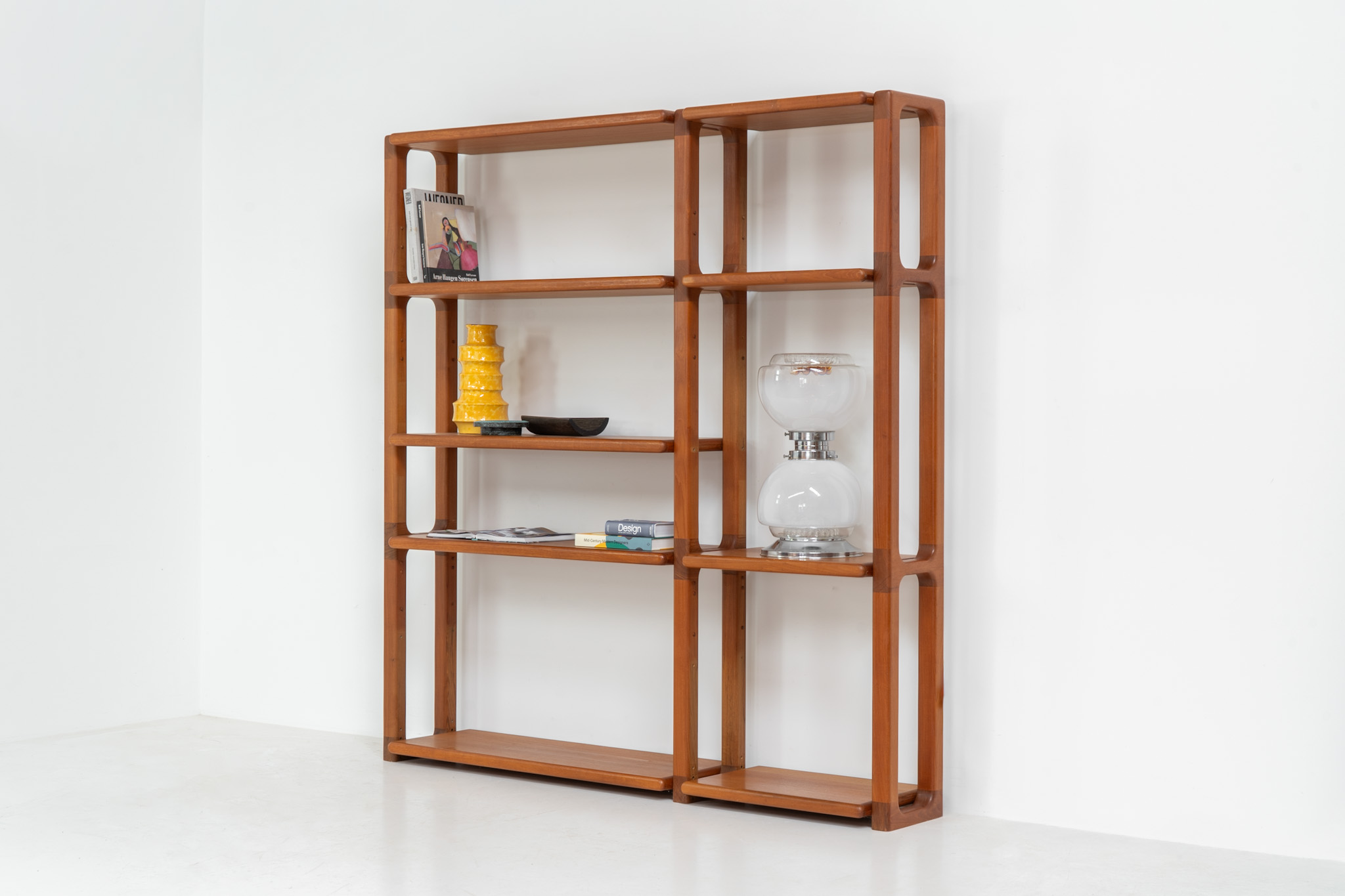 Shelving system by Svend Dyrlund (Denmark, 1960s). This shelving system, from Dyrlund’s 3000 series, is a true mid-century masterpiece. It combines bold, organic forms with substantial panel construction and refined, invisible joinery, resulting in a design that feels both architectural and sculptural. The overall composition is strong and grounded, giving the piece a striking, almost monumental presence. The shelves are height-adjustable, offering flexibility while maintaining its clean, structured aesthetic. The system is in very good condition, with light, visible signs of use that contribute to its authentic vintage character.