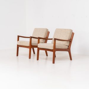 Pair of “Senator” easy chairs by Ole Wanscher for France & Son (Denmark, 1960s). An elegant pair of easy chairs and a fine example of Scandinavian Modernism. They feature a solid teak frame with a warm, natural grain, beautifully sculpted curves, and comfortable cushions upholstered in their original beige wool fabric. The chairs present beautifully and are in mint condition, fully labeled by the maker.