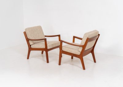 Pair of “Senator” easy chairs by Ole Wanscher for France & Son (Denmark, 1960s). An elegant pair of easy chairs and a fine example of Scandinavian Modernism. They feature a solid teak frame with a warm, natural grain, beautifully sculpted curves, and comfortable cushions upholstered in their original beige wool fabric. The chairs present beautifully and are in mint condition, fully labeled by the maker.