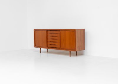 Sideboard in teak Svend Dyrlund (Denmark, 1960s). A beautifully crafted piece showcasing exceptional Danish design and craftsmanship. It features two sliding doors with adjustable shelves and six elegant drawers, offering generous and flexible storage. The softly rounded edges and organic lines give the sideboard a refined, timeless character. In very good condition.