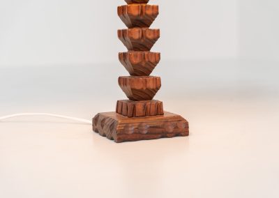 Sculptural table lamp in the manner of Charles Dudouyt (France, 1950s). This lamp offers a refined blend of beautiful textures and a highly sculptural silhouette. It has a handcrafted wooden base with lots of detail, complimented by a linnen shade. The lamp remains in splendid condition.