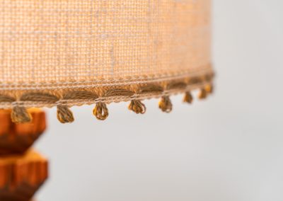 Sculptural table lamp in the manner of Charles Dudouyt (France, 1950s). This lamp offers a refined blend of beautiful textures and a highly sculptural silhouette. It has a handcrafted wooden base with lots of detail, complimented by a linnen shade. The lamp remains in splendid condition.