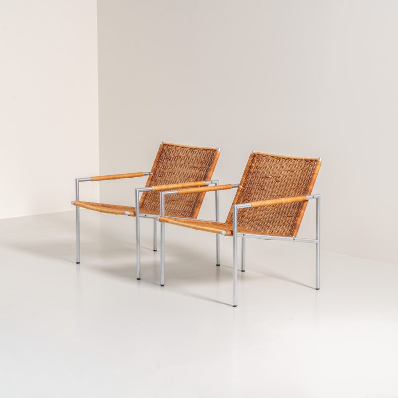 Early pair of modernist “SZ01” arm chairs by Martin Visser for Spectrum (The Netherlands, 1960s). These modernist design icons embody Visser’s minimalistic and functional design philosophy. Featuring a lightweight chromed tubular steel frame and beautiful rattan seats and backrests. Both chairs are in amazing vintage condition, with some visible wear and rust that only enhances their authenticity and charm.