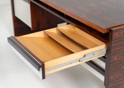 Rare double-sided “Vario” desk by Werner Wölfer for V-Form (Belgium, 1960s). This exceptionally beautiful piece is a true example of top-quality Belgian craftsmanship. Made from Rosewood, it showcases sleek aesthetics with contrasting details and a wonderful vivid woodgrain. It offers four drawers, a large top and a finished backside, making it an ideal piece for placement in the center of a room. The desk is restored and in very good condition, with minor using traces.