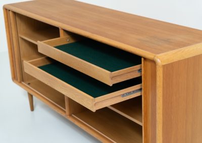 Oak sideboard with tambour doors by Kibaek Møbelfabrik (Denmark, 1960s). A beautifully crafted piece showcasing exceptional Danish design and craftsmanship. It features two tambour doors with adjustable shelves and two drawers on the inside, offering generous and flexible storage. The softly rounded edges and organic lines give the sideboard a refined, timeless character. In good condition with a mark/stain on top.