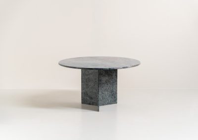 Striking dining table in solid Juparana Granite (Italy, 1970s). A beautifully sculptural piece, crafted entirely from solid Juparana Granite and distinguished by the unbelievably rich and unique grain of its tabletop. The natural variation in the stone gives the surface an almost painterly quality, making each angle of the table slightly different. Large and substantial, yet remarkably minimalistic, the table has a strong monolithic presence. The thick circular top is balanced by a sculptural three-sided pedestal base, creating a striking silhouette while keeping the overall design exceptionally clean. With its generous 130 cm diameter, the table comfortably accommodates up to six chairs. The tabletop and pedestal base are two separate pieces, making transportation and installation considerably easier despite its substantial weight. The table is in amazing condition, with no chips or structural damage.