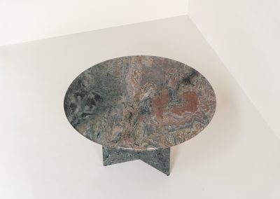 Striking dining table in solid Juparana Granite (Italy, 1970s). A beautifully sculptural piece, crafted entirely from solid Juparana Granite and distinguished by the unbelievably rich and unique grain of its tabletop. The natural variation in the stone gives the surface an almost painterly quality, making each angle of the table slightly different. Large and substantial, yet remarkably minimalistic, the table has a strong monolithic presence. The thick circular top is balanced by a sculptural three-sided pedestal base, creating a striking silhouette while keeping the overall design exceptionally clean. With its generous 130 cm diameter, the table comfortably accommodates up to six chairs. The tabletop and pedestal base are two separate pieces, making transportation and installation considerably easier despite its substantial weight. The table is in amazing condition, with no chips or structural damage.