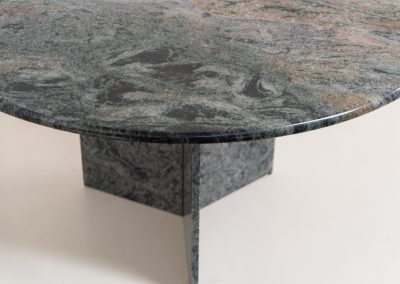 Striking dining table in solid Juparana Granite (Italy, 1970s). A beautifully sculptural piece, crafted entirely from solid Juparana Granite and distinguished by the unbelievably rich and unique grain of its tabletop. The natural variation in the stone gives the surface an almost painterly quality, making each angle of the table slightly different. Large and substantial, yet remarkably minimalistic, the table has a strong monolithic presence. The thick circular top is balanced by a sculptural three-sided pedestal base, creating a striking silhouette while keeping the overall design exceptionally clean. With its generous 130 cm diameter, the table comfortably accommodates up to six chairs. The tabletop and pedestal base are two separate pieces, making transportation and installation considerably easier despite its substantial weight. The table is in amazing condition, with no chips or structural damage.