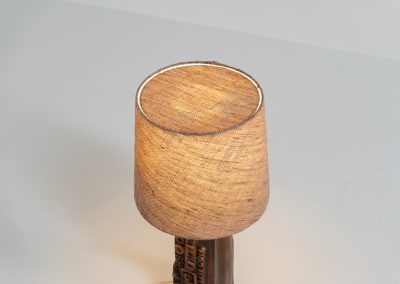 Sculptural “Kennegie” ceramic lamp by Peter Ellery for Tremaen (UK, 1960s). This lamp offers a refined blend of beautiful textures and timeless design. It has a handcrafted ceramic base with earthy colors and graphic engravings. The lamp remains in splendid condition.