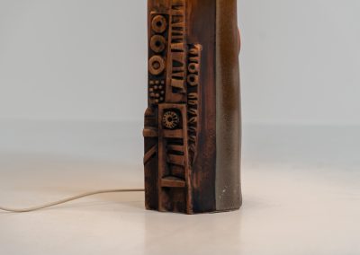 Sculptural “Kennegie” ceramic lamp by Peter Ellery for Tremaen (UK, 1960s). This lamp offers a refined blend of beautiful textures and timeless design. It has a handcrafted ceramic base with earthy colors and graphic engravings. The lamp remains in splendid condition.
