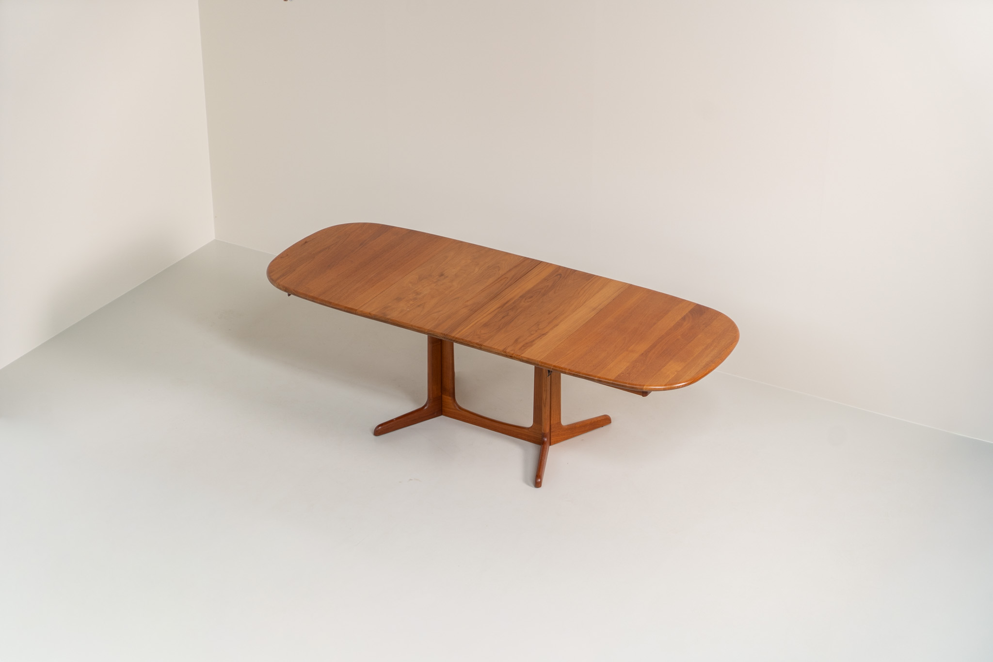 Extendable dining table by Gudme Møbelfabrik (Denmark, 1960s). The table is crafted out of solid teak and features stunning organic lines. It is easily extendable with either one or two extension plates, fitting up to 8 and possibly even 10 chairs. In very good condition with some minor using traces. Labeled by maker.