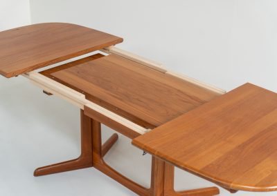 Extendable dining table by Gudme Møbelfabrik (Denmark, 1960s). The table is crafted out of solid teak and features stunning organic lines. It is easily extendable with either one or two extension plates, fitting up to 8 and possibly even 10 chairs. In very good condition with some minor using traces. Labeled by maker.