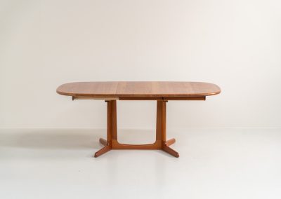 Extendable dining table by Gudme Møbelfabrik (Denmark, 1960s). The table is crafted out of solid teak and features stunning organic lines. It is easily extendable with either one or two extension plates, fitting up to 8 and possibly even 10 chairs. In very good condition with some minor using traces. Labeled by maker.